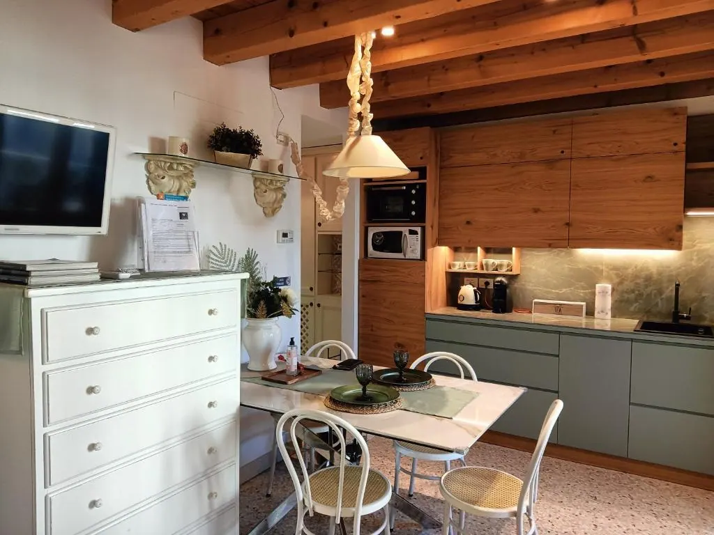Cucina e zona pranzo di Suite Latina, sotto le travi a vista in legno